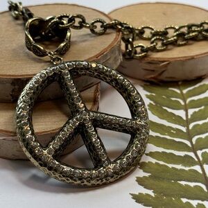 Peace sign in antique gold tone with clear rhinestones on 20” chain